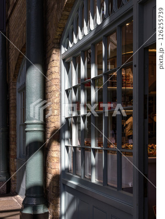 Sunbeam filtered shining through bakery shop glass window display. Sunbeam filtered shining through bakery shop glass window display. 126255739