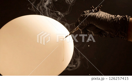 Tattoo needle puncturing a water balloon . Background concept. Generated Image 126257415