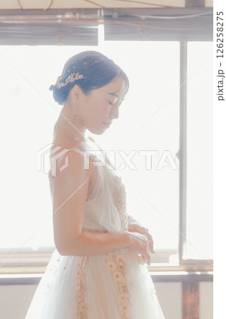 白いドレスをまとい、自然光の中でこちらを見つめる女性 白いドレスをまとい、自然光の中でこちらを見つめる女性 126258275