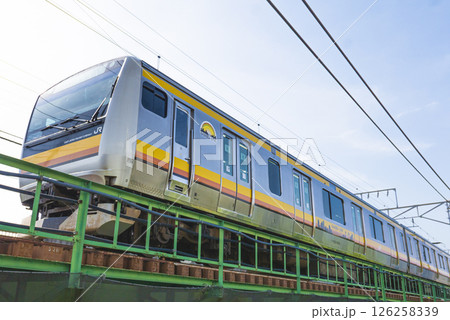 真上のレールを走るJR南武線のE233系車両の写真 126258339