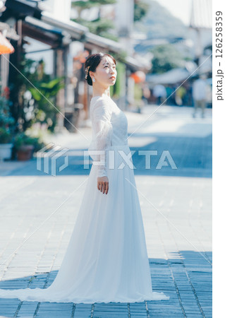 伝統的な町並みに立つウェディングドレス姿の女性のポートレート 伝統的な町並みに立つウェディングドレス姿の女性のポートレート 126258359
