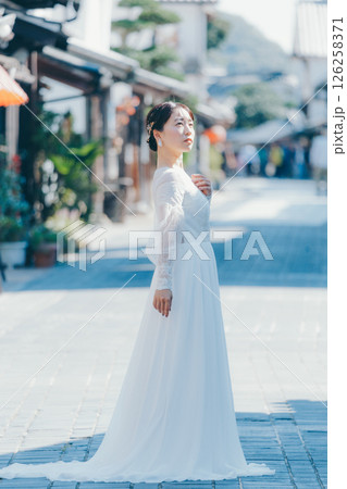 伝統的な町並みに立つウェディングドレス姿の女性のポートレート 伝統的な町並みに立つウェディングドレス姿の女性のポートレート 126258371