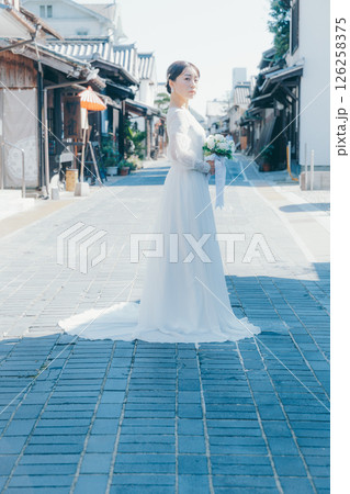 伝統的な町並みに立つウェディングドレス姿の女性のポートレート 伝統的な町並みに立つウェディングドレス姿の女性のポートレート 126258375