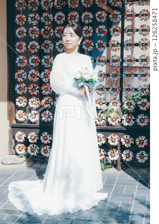 和風の花装飾を背景に立つウェディングドレス姿の女性のポートレート 和風の花装飾を背景に立つウェディングドレス姿の女性のポートレート 126258471
