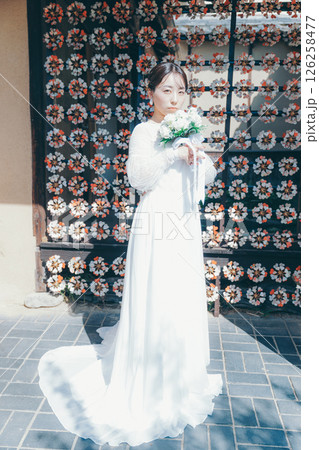 和風の花装飾を背景に立つウェディングドレス姿の女性のポートレート 和風の花装飾を背景に立つウェディングドレス姿の女性のポートレート 126258477