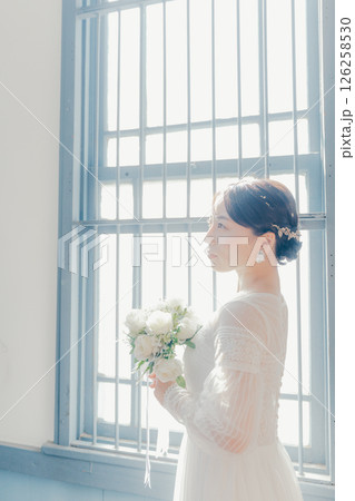 白いドレスを着た女性が窓際に立つシルエット風ポートレート 白いドレスを着た女性が窓際に立つシルエット風ポートレート 126258530