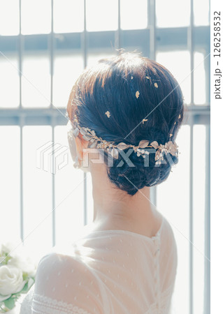 白いドレスを着た女性が窓際に立つシルエット風ポートレート 126258532