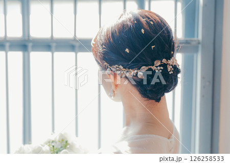 白いドレスを着た女性が窓際に立つシルエット風ポートレート 126258533