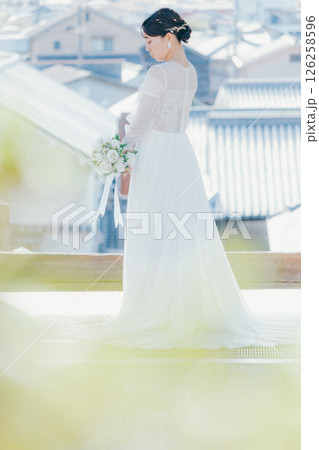 高台の神社から町並みを望むウェディングドレス姿の女性のポートレート 高台の神社から町並みを望むウェディングドレス姿の女性のポートレート 126258596