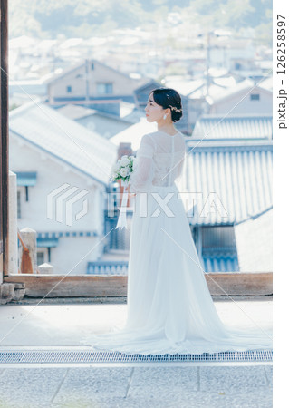 高台の神社から町並みを望むウェディングドレス姿の女性のポートレート 高台の神社から町並みを望むウェディングドレス姿の女性のポートレート 126258597