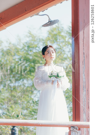 高台の神社から町並みを望むウェディングドレス姿の女性のポートレート 高台の神社から町並みを望むウェディングドレス姿の女性のポートレート 126258601