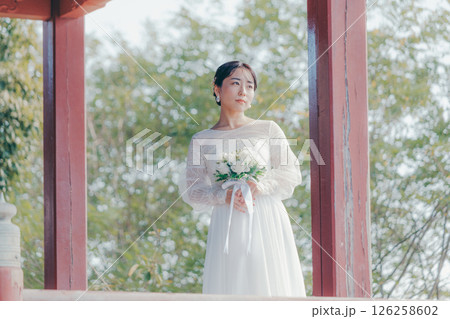 高台の神社から町並みを望むウェディングドレス姿の女性のポートレート 126258602