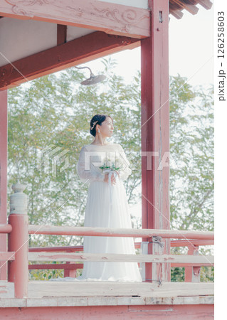 高台の神社から町並みを望むウェディングドレス姿の女性のポートレート 高台の神社から町並みを望むウェディングドレス姿の女性のポートレート 126258603