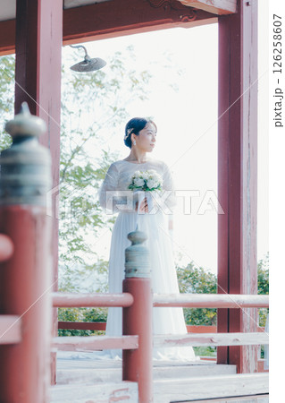 高台の神社から町並みを望むウェディングドレス姿の女性のポートレート 高台の神社から町並みを望むウェディングドレス姿の女性のポートレート 126258607