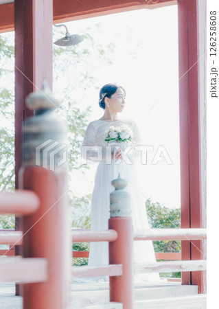 高台の神社から町並みを望むウェディングドレス姿の女性のポートレート 126258608