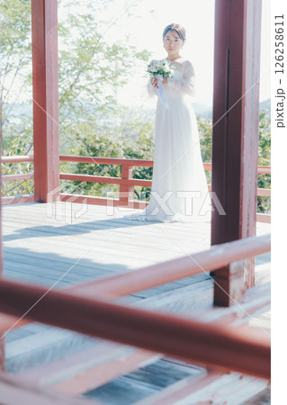 高台の神社から町並みを望むウェディングドレス姿の女性のポートレート 高台の神社から町並みを望むウェディングドレス姿の女性のポートレート 126258611
