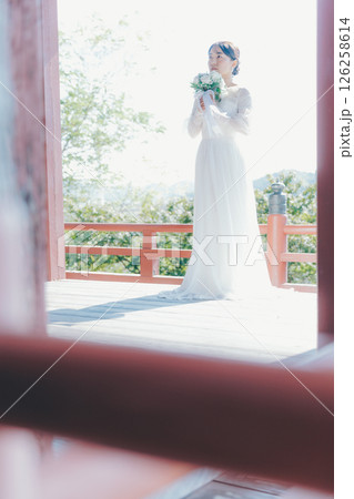 高台の神社から町並みを望むウェディングドレス姿の女性のポートレート 126258614