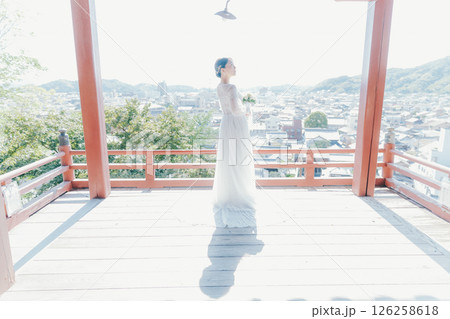 高台の神社から町並みを望むウェディングドレス姿の女性のポートレート 126258618