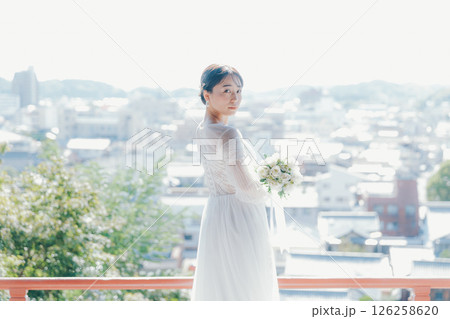高台の神社から町並みを望むウェディングドレス姿の女性のポートレート 高台の神社から町並みを望むウェディングドレス姿の女性のポートレート 126258620