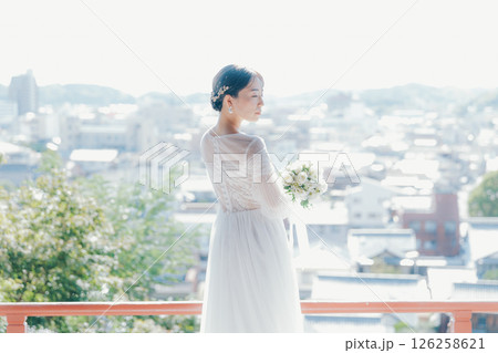 高台の神社から町並みを望むウェディングドレス姿の女性のポートレート 高台の神社から町並みを望むウェディングドレス姿の女性のポートレート 126258621