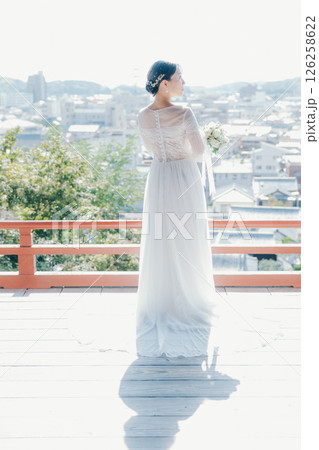 高台の神社から町並みを望むウェディングドレス姿の女性のポートレート 126258622