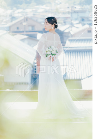 高台の神社から町並みを望むウェディングドレス姿の女性のポートレート 126258625