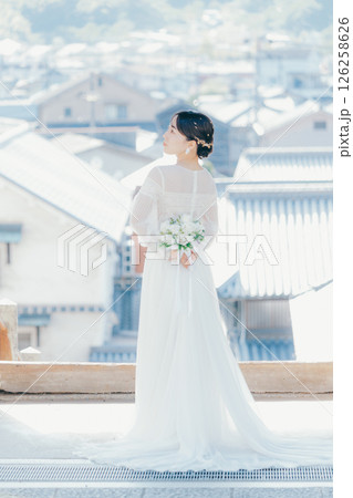 高台の神社から町並みを望むウェディングドレス姿の女性のポートレート 126258626