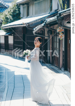 古い町並みで白いウェディングドレスを着た女性が振り返るポートレート 126258635