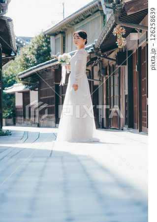 古い町並みで白いウェディングドレスを着た女性が振り返るポートレート 126258639