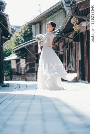 古い町並みで白いウェディングドレスを着た女性が振り返るポートレート 126258640