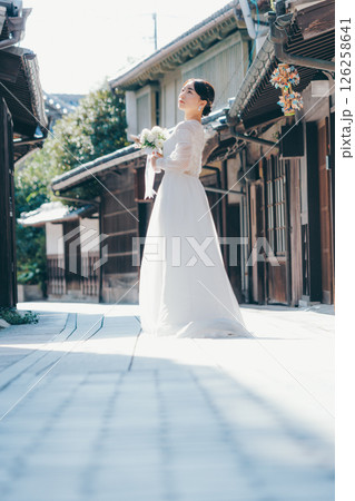 古い町並みで白いウェディングドレスを着た女性が振り返るポートレート 126258641