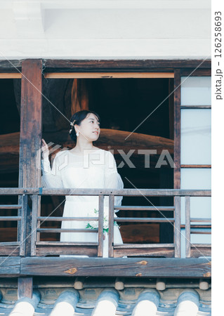 町屋の二階から外を眺めるウェディングドレス姿の女性 126258693