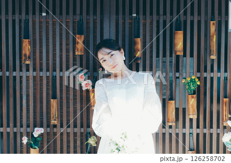 和の装飾を背景に佇むウェディングドレス姿の女性ポートレート 126258702