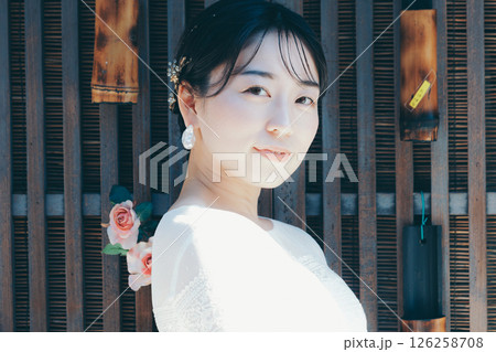 和の装飾を背景に佇むウェディングドレス姿の女性ポートレート 126258708