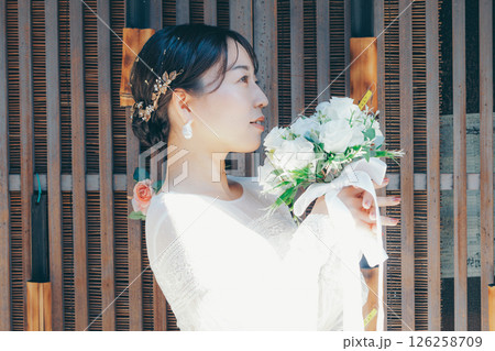 和の装飾を背景に佇むウェディングドレス姿の女性ポートレート 和の装飾を背景に佇むウェディングドレス姿の女性ポートレート 126258709