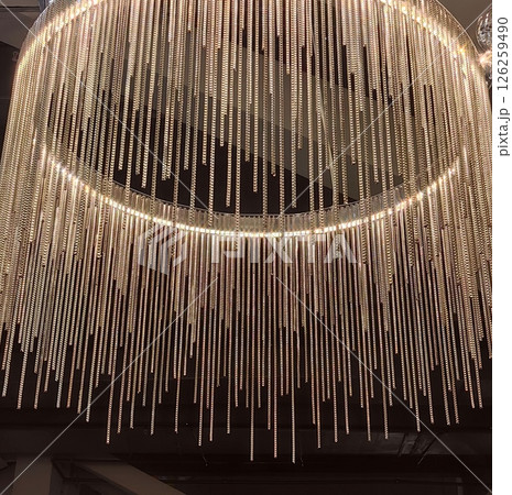 elegant chandelier with cascading crystal strands enhancing modern interior decor. close up. elegant chandelier with cascading crystal strands enhancing modern interior decor. close up. 126259490
