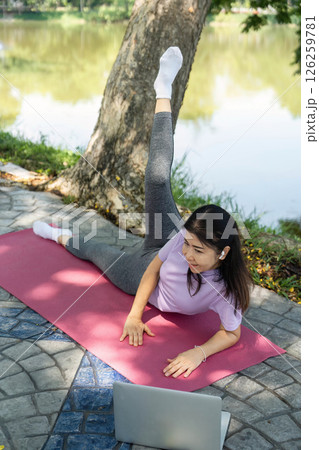 Wellness and Yoga Practice. Woman practicing yoga outdoors by the lake. Wellness and Yoga Practice. Woman practicing yoga outdoors by the lake. 126259781