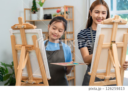 Creative bonding through art: Mother and daughter painting together Creative bonding through art: Mother and daughter painting together 126259813