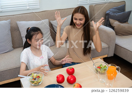 Wellness through healthy eating: Mother and daughter enjoying meals together Wellness through healthy eating: Mother and daughter enjoying meals together 126259839