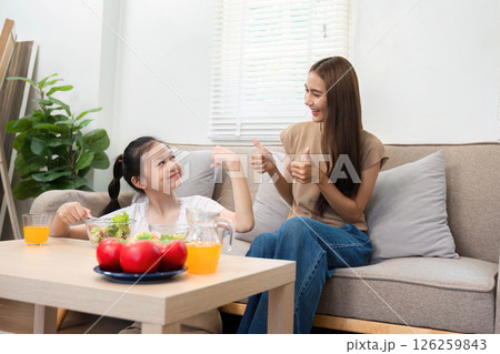Wellness moments: Mother and daughter thumbs up over diet choices Wellness moments: Mother and daughter thumbs up over diet choices 126259843