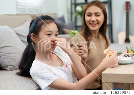 Wellness fun: girl playfully reacting with cookie and salad Wellness fun: girl playfully reacting with cookie and salad 126259873