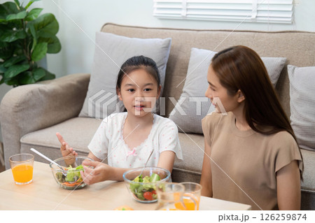 Wellness: Daughter sharing ideas with mother during healthy meal Wellness: Daughter sharing ideas with mother during healthy meal 126259874