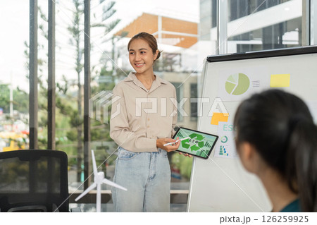 Sustainable Business Strategies. Woman presents ESG initiatives to her colleagues. 126259925
