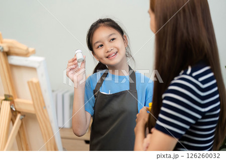 Creative Learning: Young Girl Showing Paint to Her Mentor Creative Learning: Young Girl Showing Paint to Her Mentor 126260032