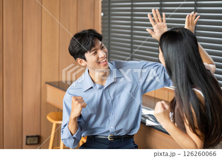 Joyful Business Interaction. Two colleagues celebrating a successful idea in a contemporary office. 126260066