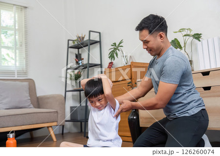 Family fitness motivation father helping son stretch at home 126260074