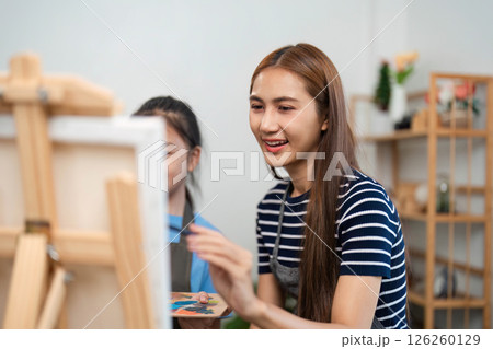 Family time with a mother teaching painting techniques to her child Family time with a mother teaching painting techniques to her child 126260129