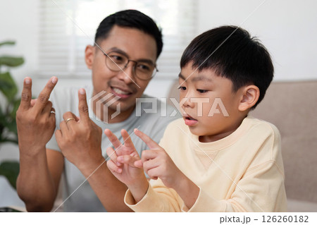 Homeschool activity with father showing math problems to son Homeschool activity with father showing math problems to son 126260182