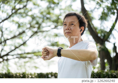 Wellness and Exercise. Senior man stretching outdoors in a park. 126260240