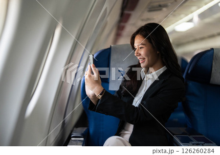 Business travel with a young professional woman enjoying a video call on an airplane 126260284